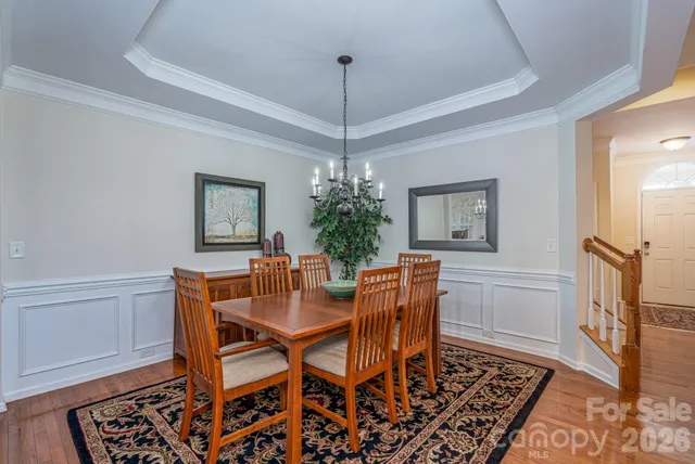 a dining room with furniture a chandelier and wooden floor