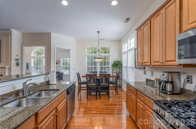 a kitchen with granite countertop a sink stove and cabinets
