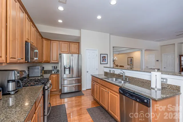 a kitchen with stainless steel appliances granite countertop a sink stove and refrigerator