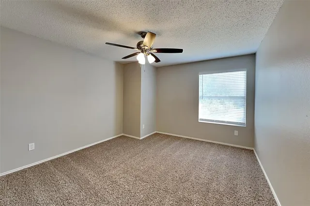 a view of room with a ceiling fan and a window