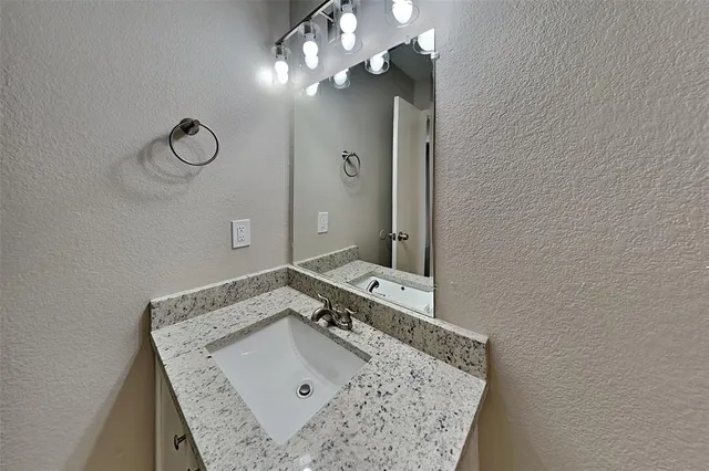 a bathroom with a sink vanity and mirror
