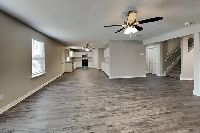 a view of a livingroom with a ceiling fan window and wooden floor