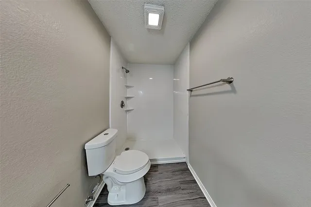 a bathroom with a toilet and a shower