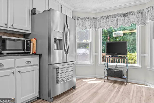 a kitchen with granite countertop a refrigerator and a stove top oven