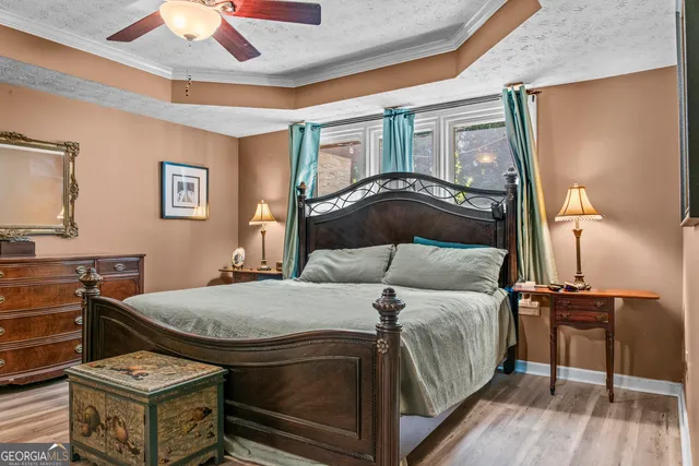 a bedroom with a bed and a dresser with wooden floor