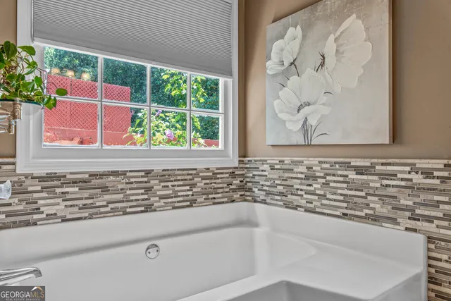 a bathroom with a granite countertop sink and a bathtub