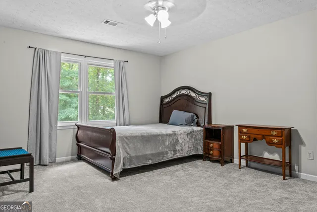 a bedroom with a bed and a ceiling fan