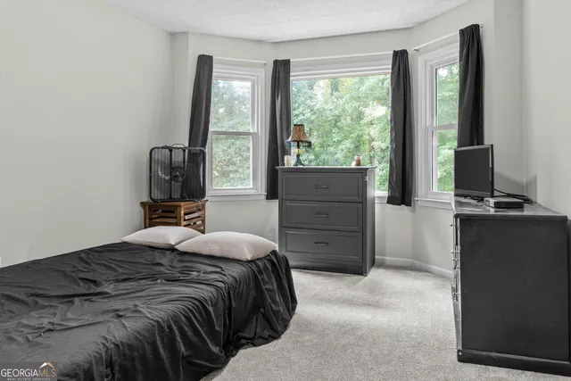 a bedroom with a bed and large windows