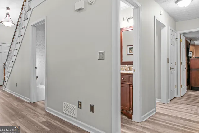 a view of a hallway with wooden floor and closet