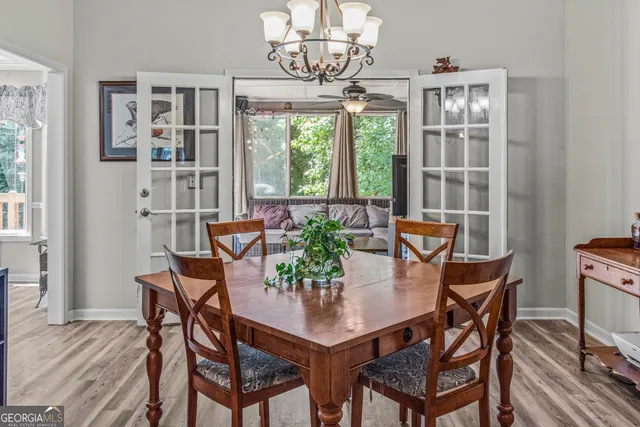 a view of a dining room with furniture a chandelier and wooden floor