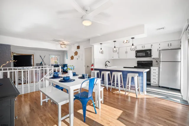 a view of a dining room with furniture a kitchen and chandelier