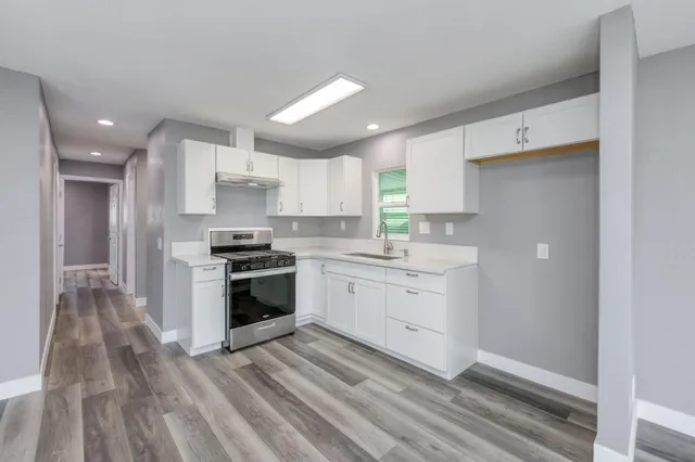 a kitchen with a stove sink and cabinets