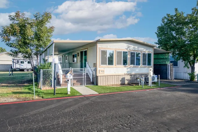 a front view of a house with a garden and trees