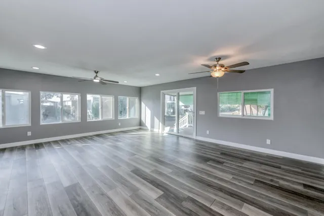 an empty room with a window and a fan