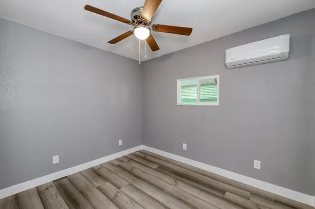 a view of empty room with window and ceiling fan