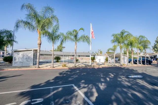 a front view of a building with cars parked