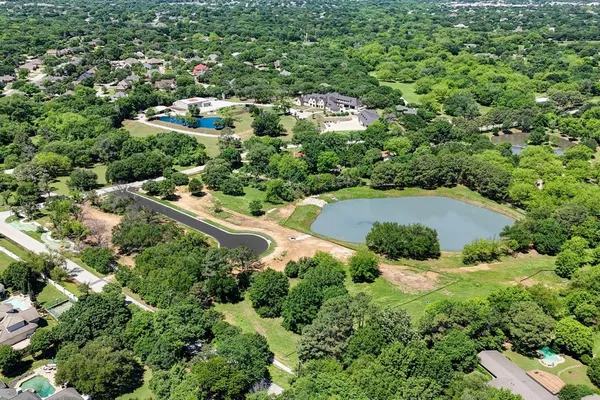 an aerial view of residential house with outdoor space and trees all around