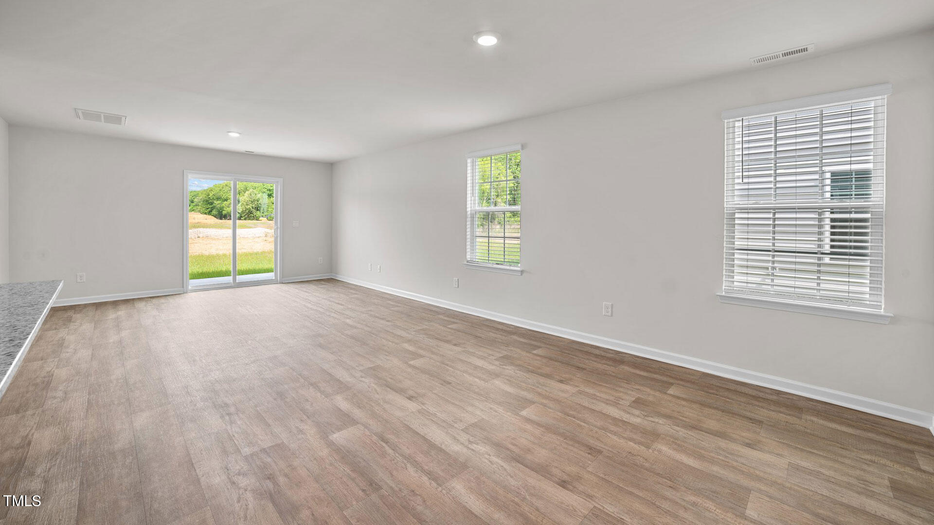 210 River Bank Road Fuquay-Varina, NC 27526 - Photo 17 of 36 a view of an empty room with wooden floor and a window