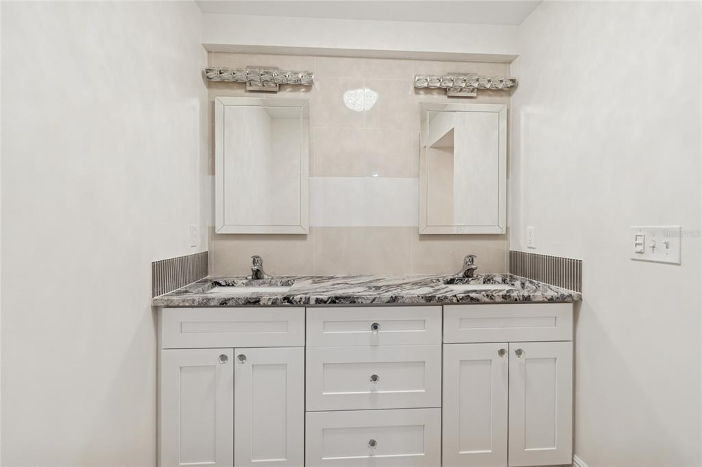 9628 Davis Road Tampa, FL 33637 - Photo 14 of 44 a bathroom with a granite countertop sink and a mirror