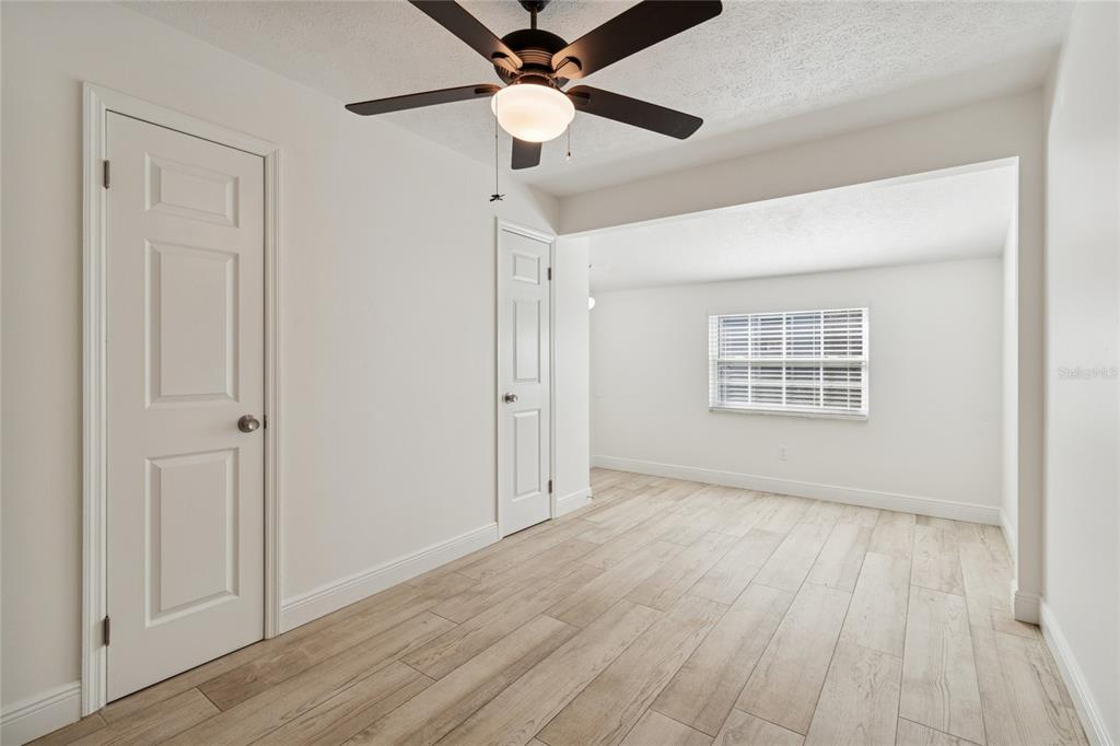 9628 Davis Road Tampa, FL 33637 - Photo 17 of 44 a view of an empty room with wooden floor and a ceiling fan