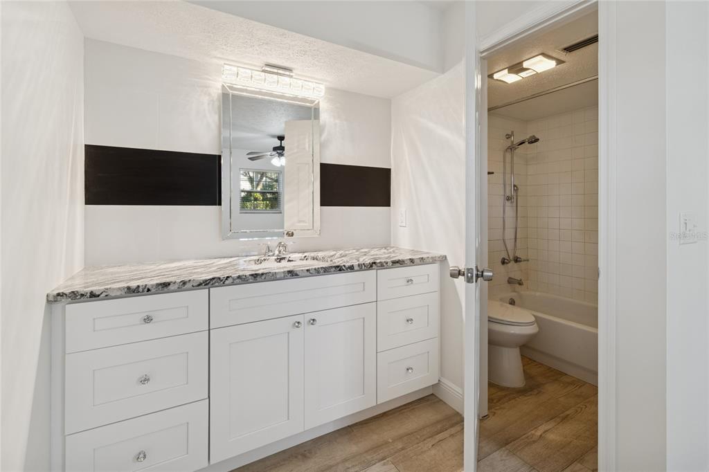 9628 Davis Road Tampa, FL 33637 - Photo 23 of 44 a bathroom with a granite countertop sink toilet and mirror