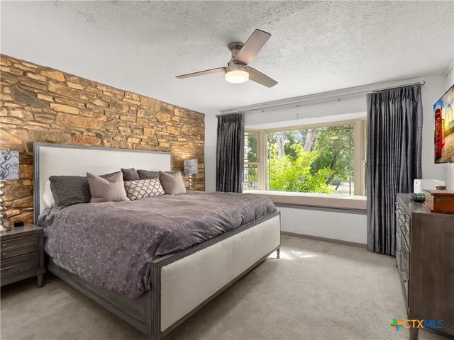 a spacious bedroom with a bed and a large window