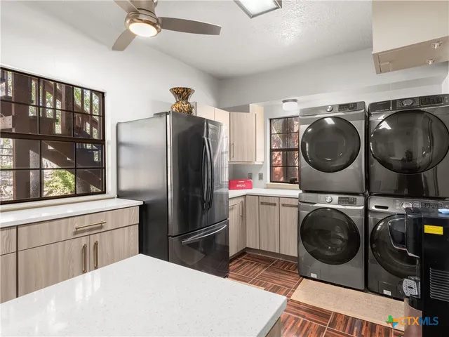 a kitchen with a refrigerator a washer and dryer