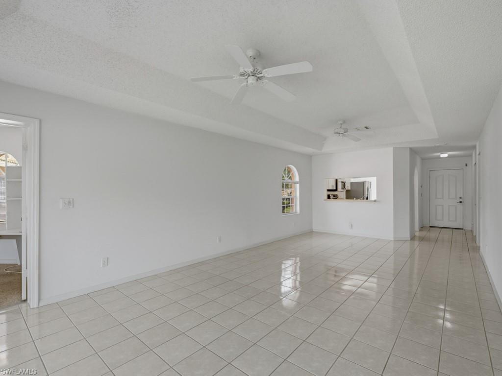 565 Augusta Boulevard, Unit 10 Naples, FL 34113 - Photo 2 of 16 an empty room with windows and ceiling fan