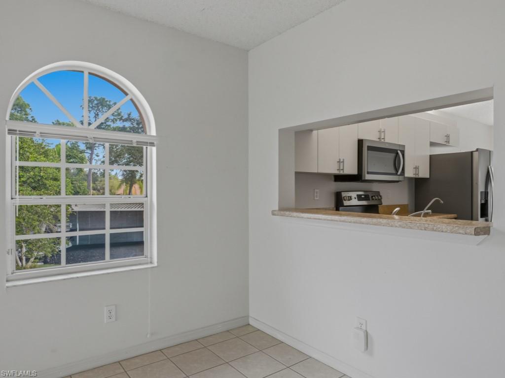 565 Augusta Boulevard, Unit 10 Naples, FL 34113 - Photo 6 of 16 a view of kitchen with stainless steel appliances granite countertop a stove a microwave and a refrigerator