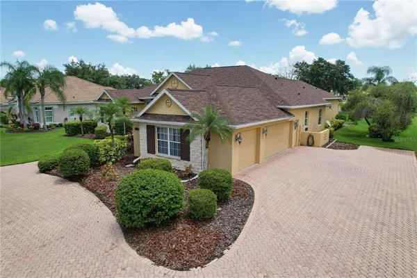 a front view of a house with a yard and potted plants