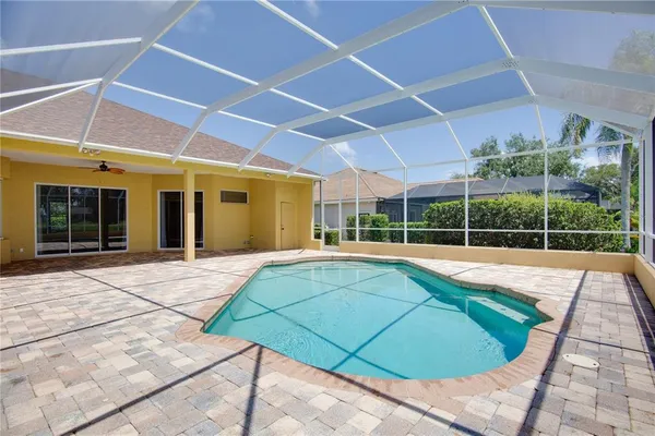 a view of a backyard with swimming pool and porch