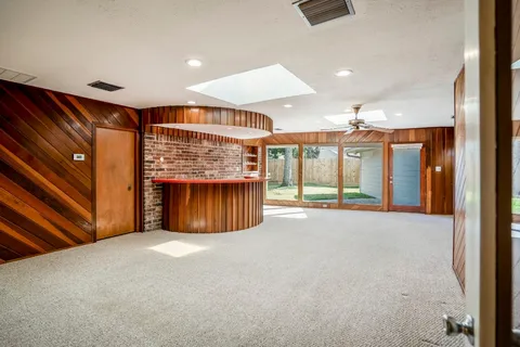 a view of an empty room with a fireplace and a window