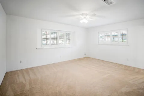 an empty room with a chandelier fan