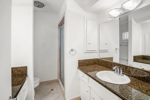 a bathroom with a granite countertop sink and a mirror