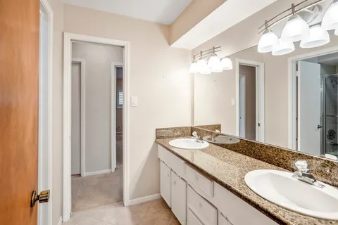 a bathroom with a granite countertop sink and a mirror