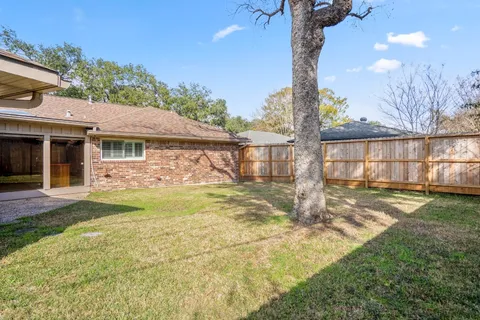 a view of a backyard with a garden and tree