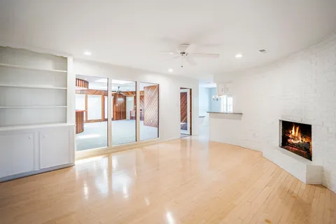 a view of an empty room with a fireplace and a window