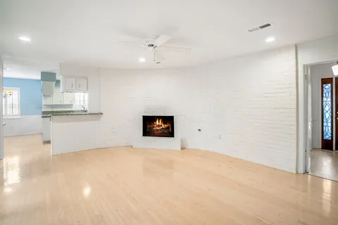 a view of an empty room with window and wooden floor