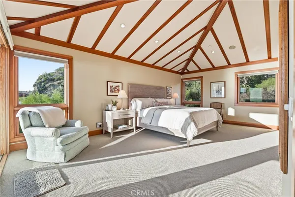 a bedroom with a bed and large window with balcony view