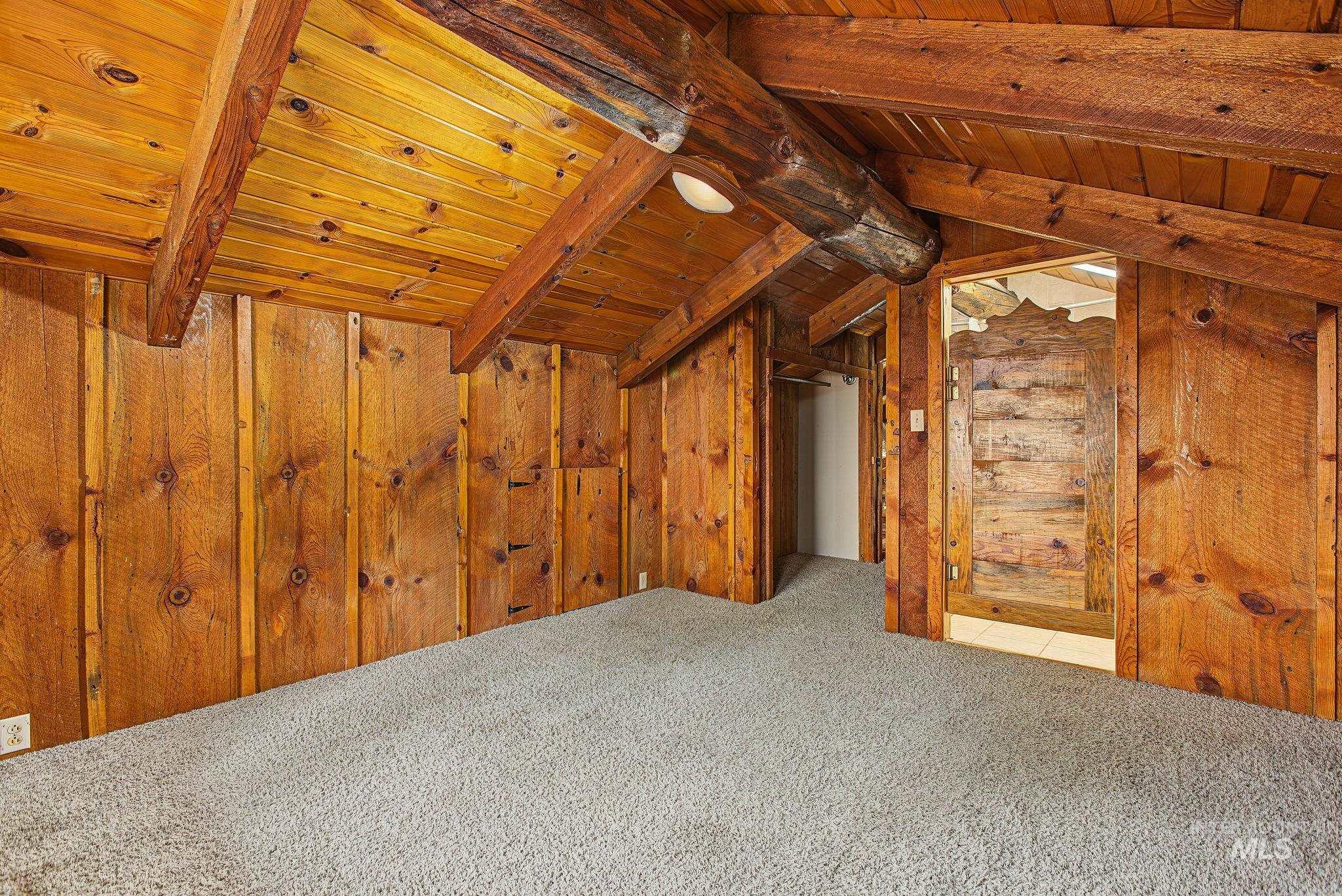 2926 Wells Bench Road Orofino, ID 83544 - Photo 30 of 48 Vaulted wood-paneled ceilings, exposed wood beams, wood-paneled walls, and plush carpeting