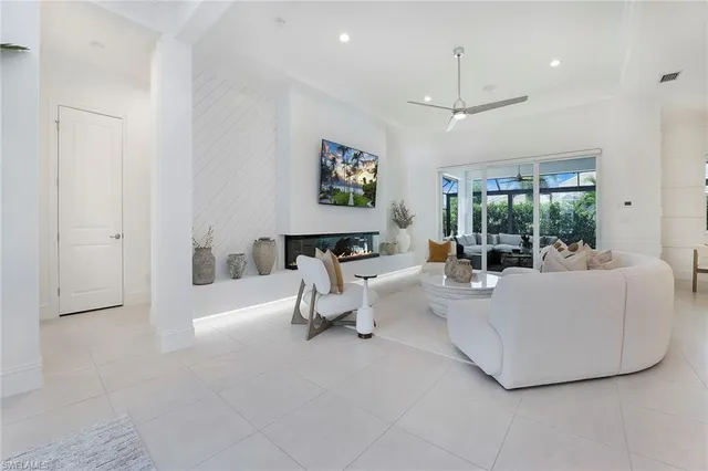 a living room with couches a fireplace and a flat screen tv