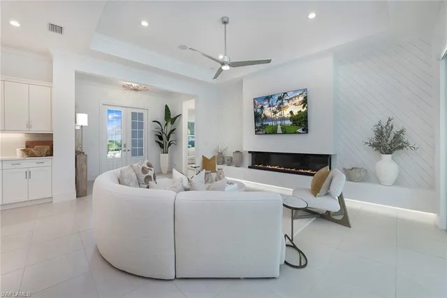 a living room with furniture a chandelier and a flat screen tv