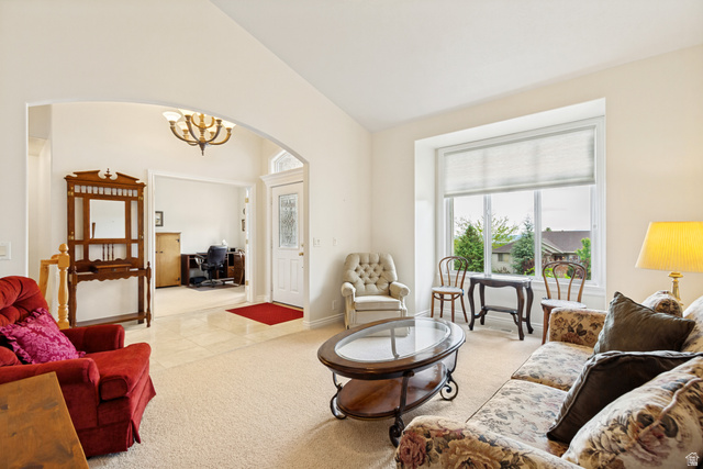298 North Canyon Road Bountiful, UT 84010 - Photo 7 of 57 Living area featuring neutral carpeting, an arched doorway, and a large front window with a pleated shade