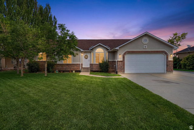 791 East Saddle Road Grantsville, UT 84029 - Photo 46 of 46 Ranch-style exterior featuring a two-car garage, brick accents, and a front entry with an arched window