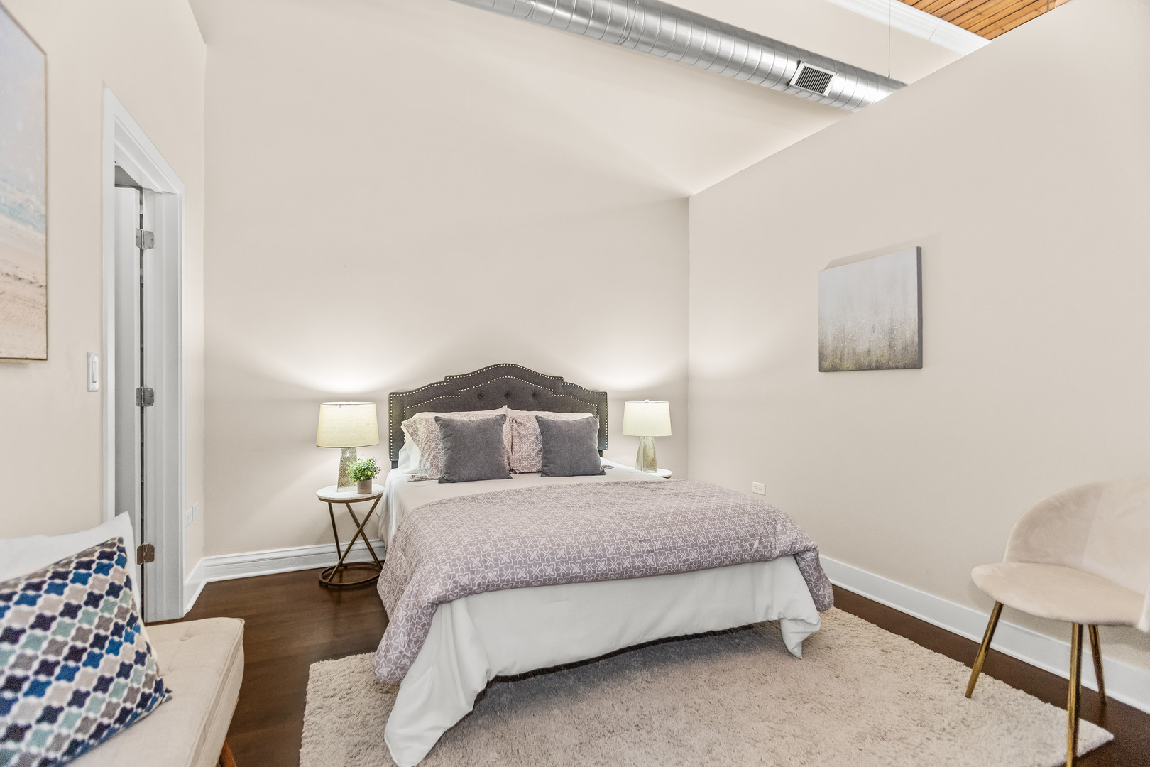 2303 South Michigan Avenue, Unit 208 Chicago, IL 60616 - Photo 9 of 21 a bedroom with a bed and a chair with the potted plant on the dresser