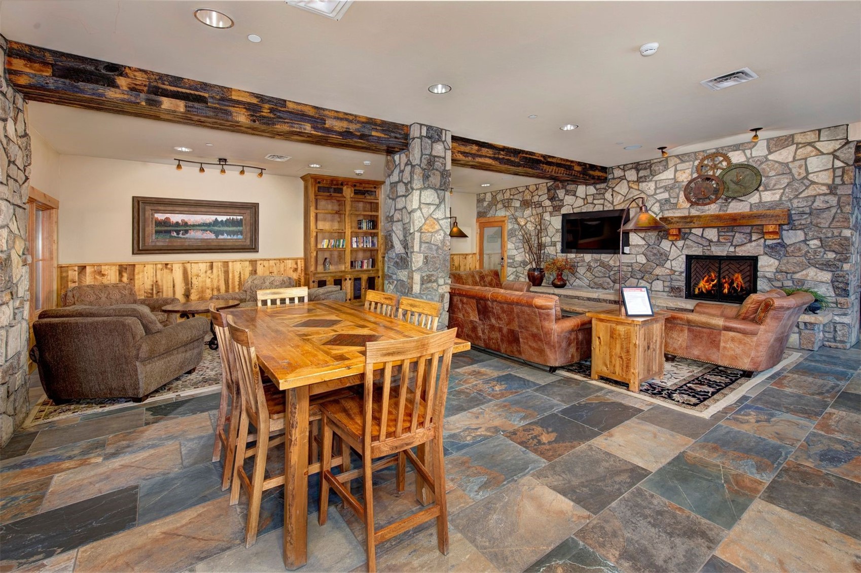 129 River Run Road, Unit 8040 Keystone, CO 80435 - Photo 20 of 50 Dining room with stone tile floors, a fireplace, beamed ceiling, a wainscoted wall, and recessed lighting