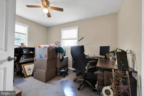 a view of a workspace with furniture and a window