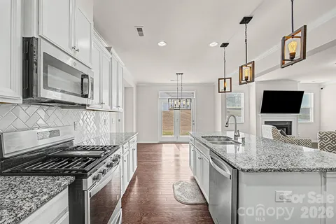a kitchen with stainless steel appliances granite countertop a stove and a microwave