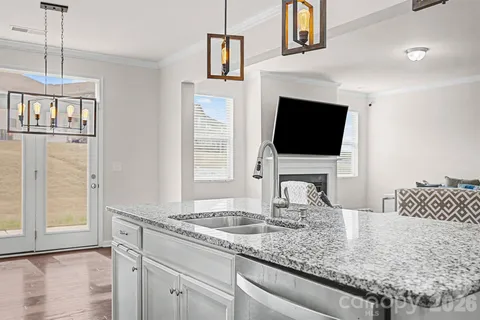 a kitchen with granite countertop a sink and a stove top oven