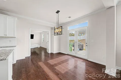 a view of an empty room with window and wooden floor